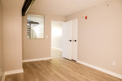 the living room and entrance to the bedroom of an apartment