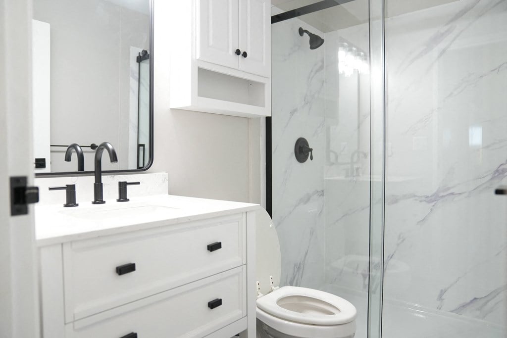 a white bathroom with a shower sink and toilet