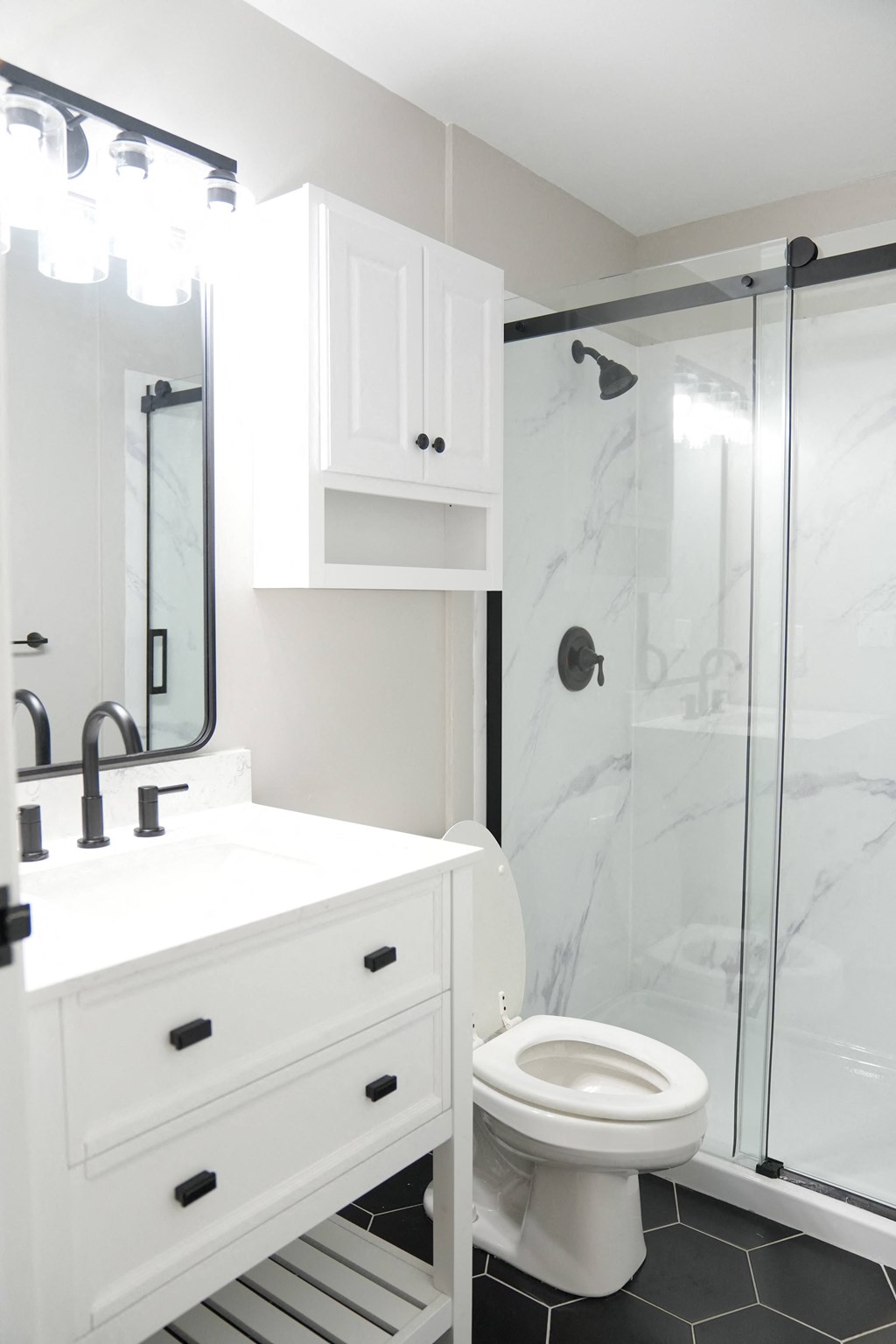 a white bathroom with a shower and a sink and a toilet