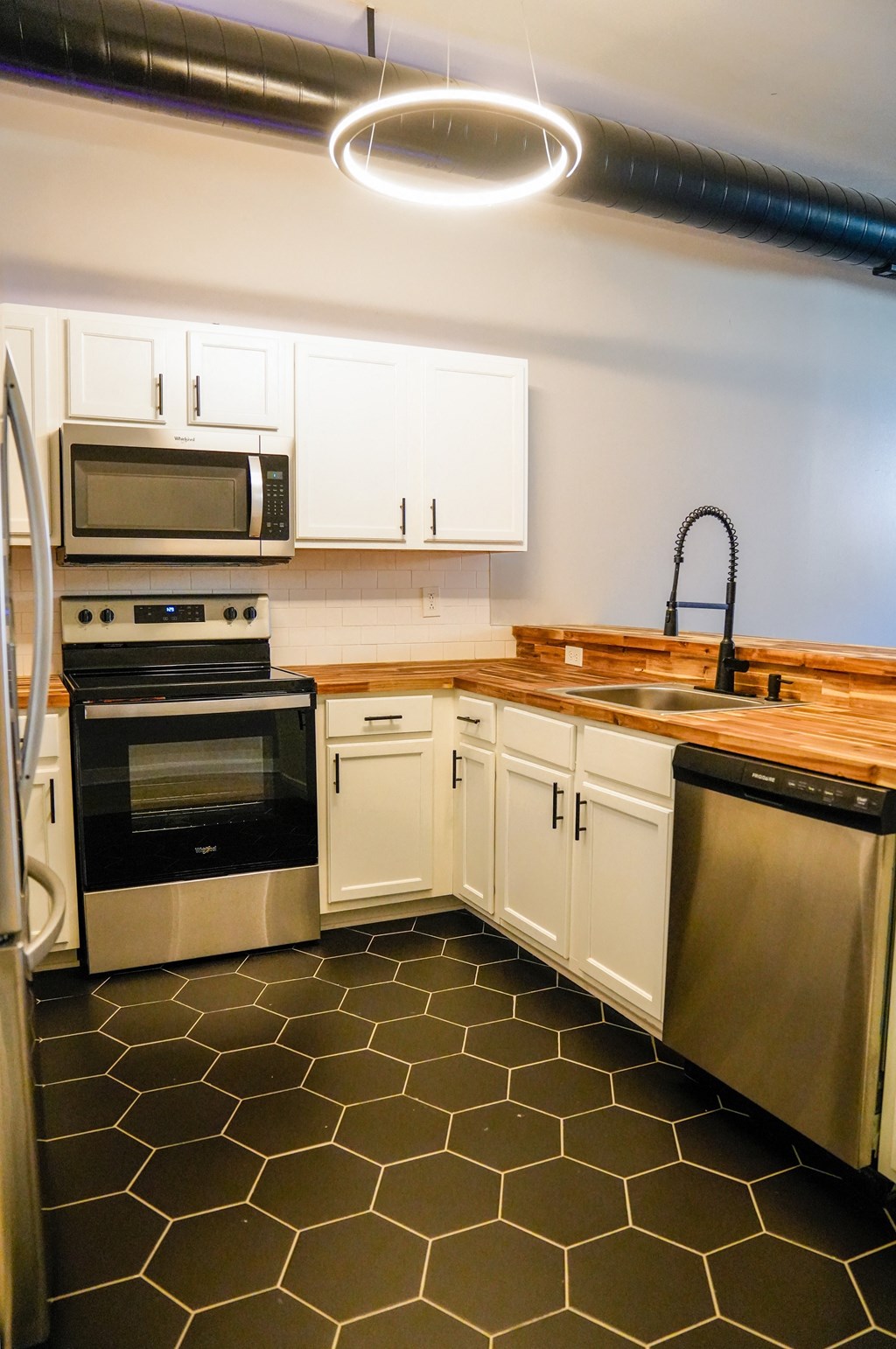 a kitchen with white cabinets and stainless steel appliances