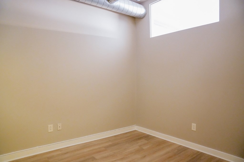 a bedroom with wooden floors and a window