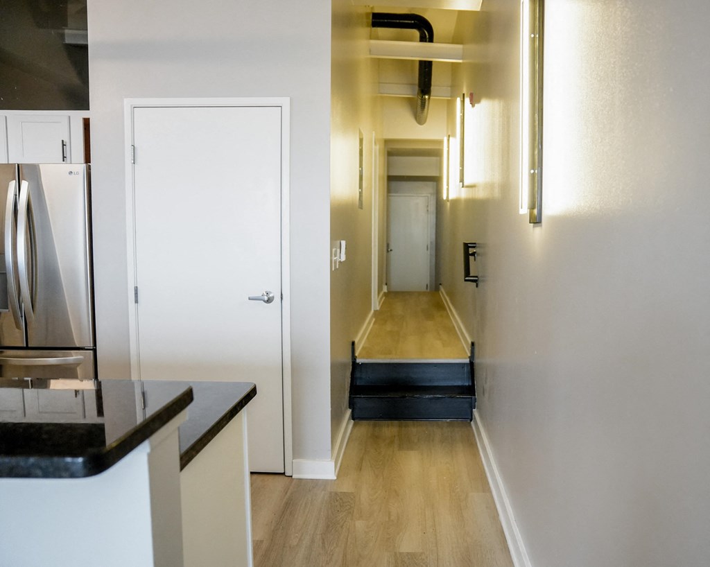 the view from the kitchen into the hallway with the door to the living room