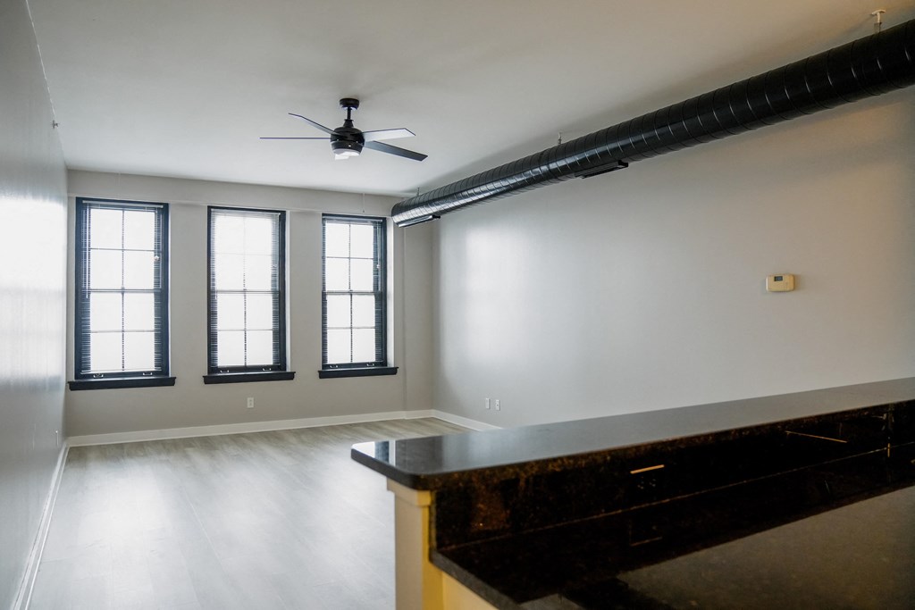 living room with a ceiling fan and windows