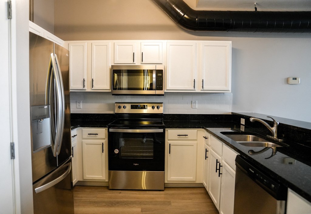 a kitchen with stainless steel appliances and white cabinets