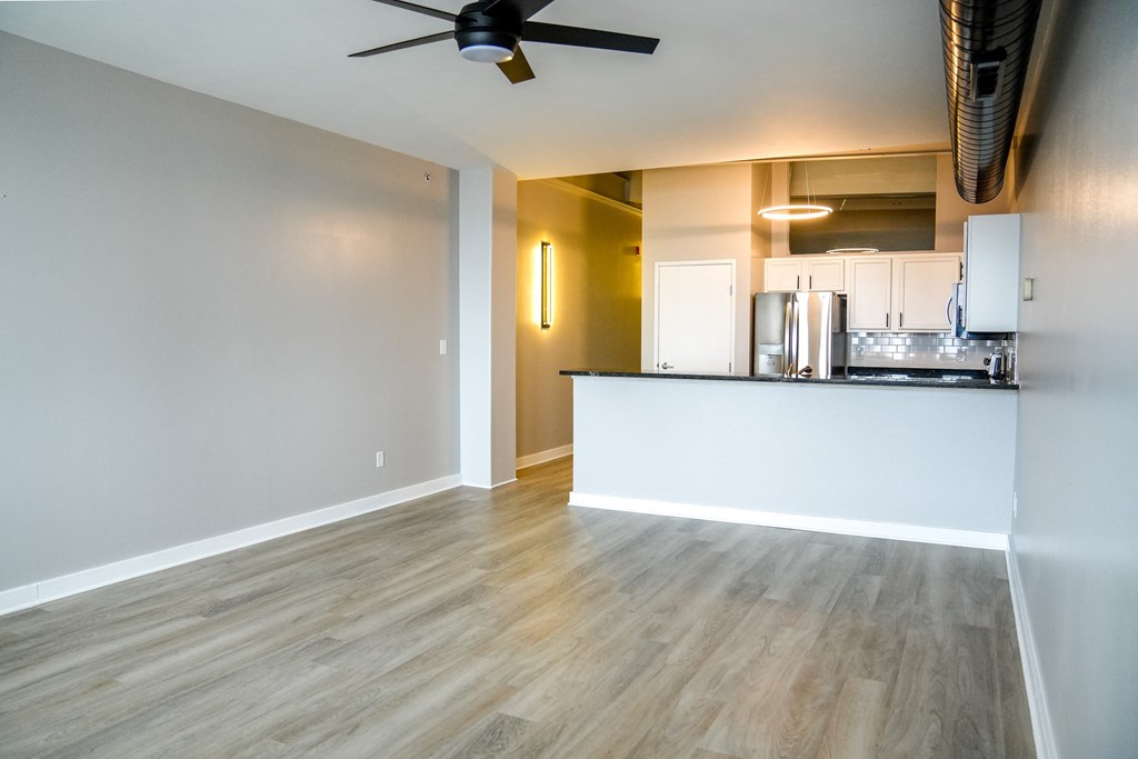 living room with a kitchen and a ceiling fan