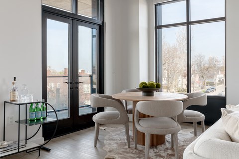 a living room with a table and chairs and a large window