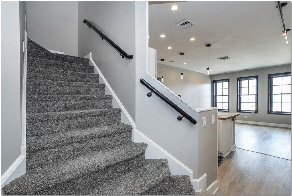 a view of a staircase in a home with gray carpet and white walls
