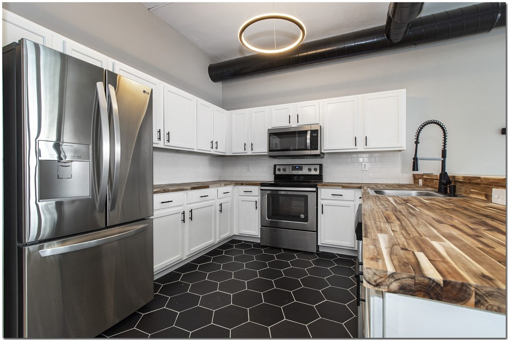 a kitchen with stainless steel appliances and a wooden counter top