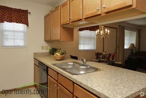 A kitchen with wooden cabinets and a granite countertop.