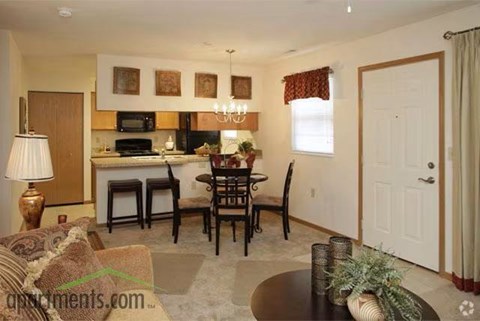 A well-lit living room with a dining table and chairs.