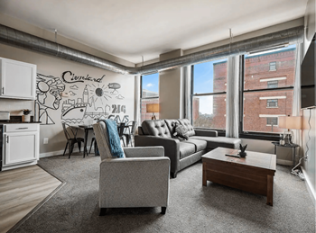 a living room with a couch and a table in front of a window
