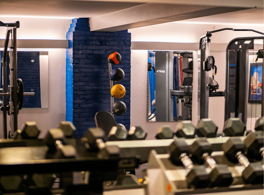 a gym with weights and a brick wall and a mirror