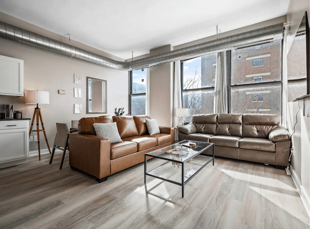 a living room with leather couches and a glass coffee table