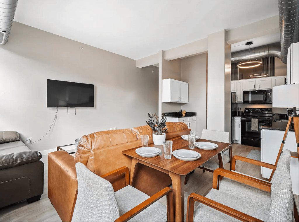 a living room with a leather couch and a wooden table