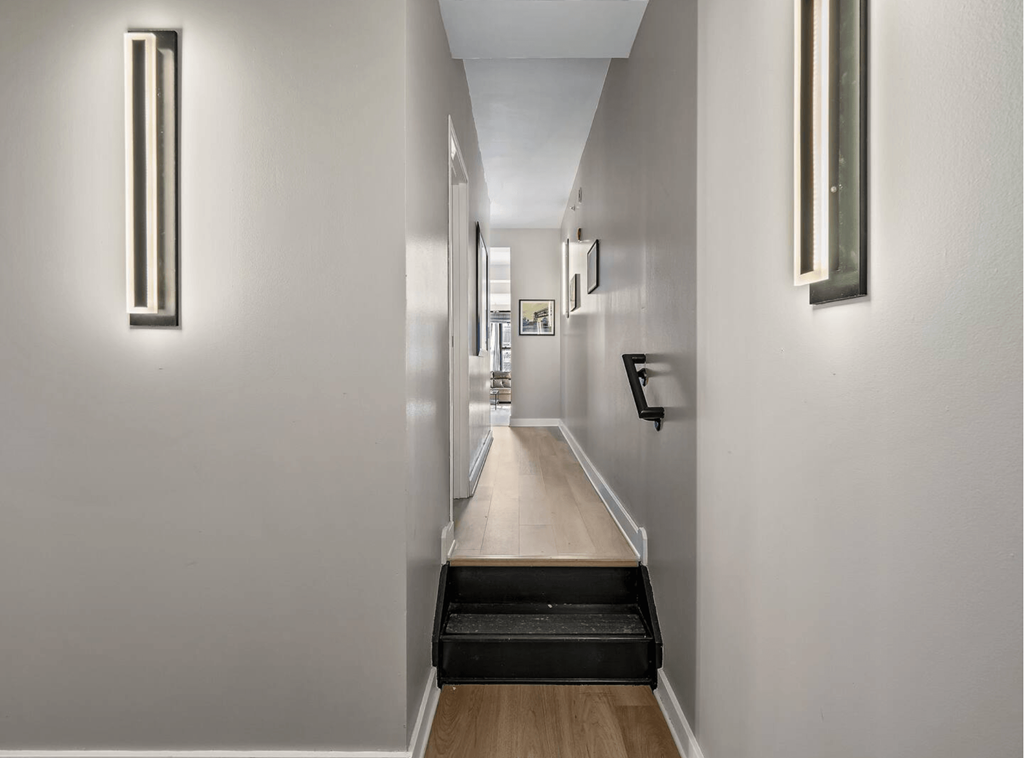 a long hallway with white walls and a long wooden counter top