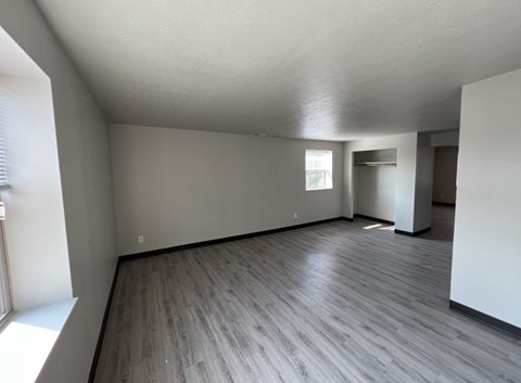 A room with wooden flooring and white walls.