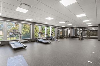 A spacious gym with treadmills, exercise bikes, and other equipment.