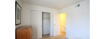 an empty room with two doors and a closet