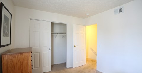 an empty room with two doors and a closet