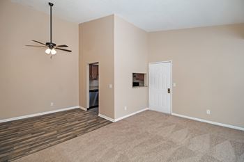 A room with a ceiling fan and a door.