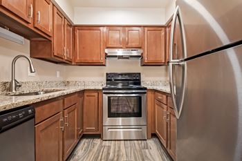 A modern kitchen with wooden cabinets and stainless steel appliances.