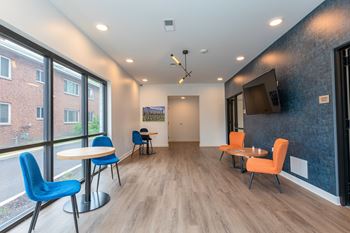A room with a white table and blue chairs. at The Lumos Apartments, Ohio, 44106