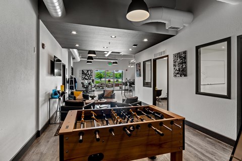 A room with a pool table and a foosball table. at Vivo Toledo Apartments, Toledo, OH, 43607