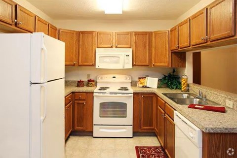 A kitchen with wooden cabinets and white appliances.