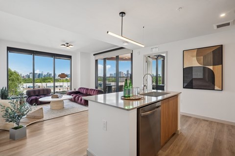 A modern kitchen with a large island and a view of the city.