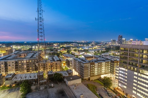 A cityscape at dusk with a prominent red tower.