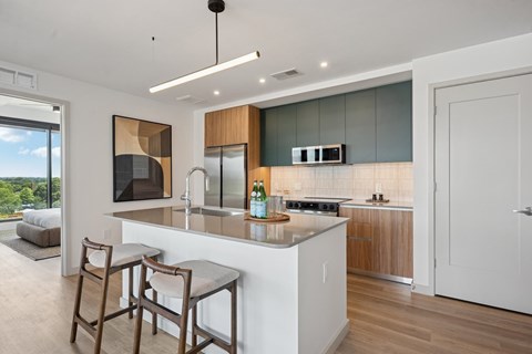 A modern kitchen with a bar area and a view of the outdoors.