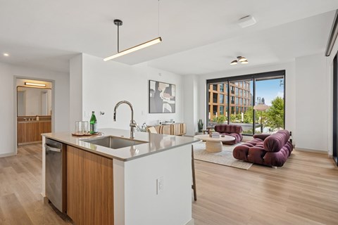 A modern kitchen with a large island and a view of the city.