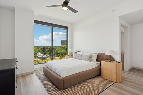 A bedroom with a large bed and a ceiling fan.