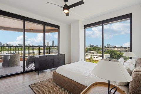 A bedroom with a large bed and a view of the city.