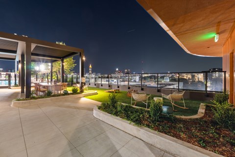 A rooftop patio with a view of the city at night.