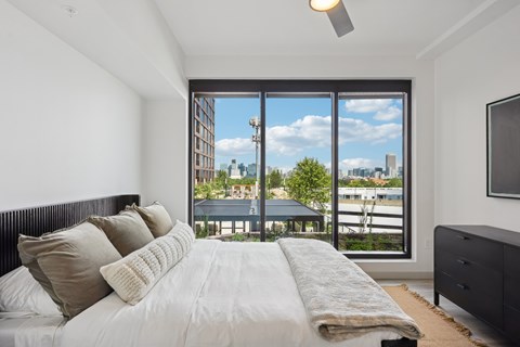 A bedroom with a large bed and a view of the city.
