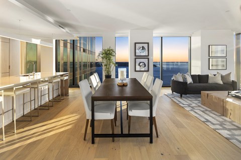 a kitchen and dining area with a wooden table and white chairs