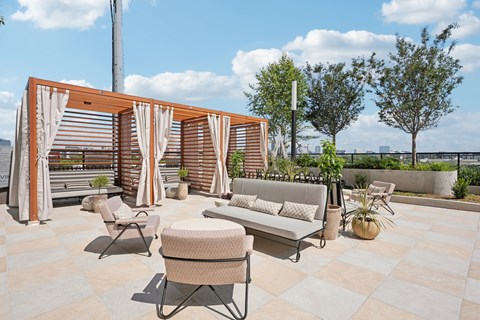 A patio with a table and chairs and a wooden structure.