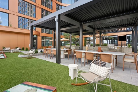 A patio with a table and chairs under a roof.