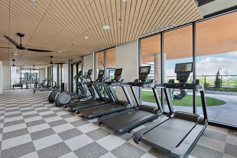 A gym with treadmills and a ceiling fan.