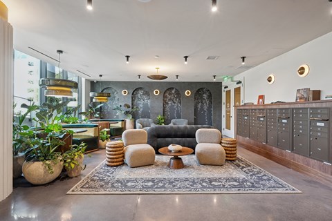 A modern living room with a grey sofa, a coffee table, and a rug in the center.