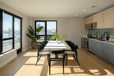 a dining room with a table and chairs and a kitchen with a large window