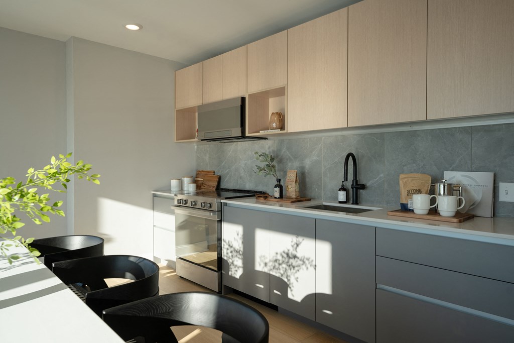 a kitchen with gray cabinets and a table and chairs