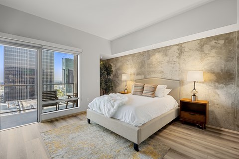 A bedroom with a large bed and a view of the city.