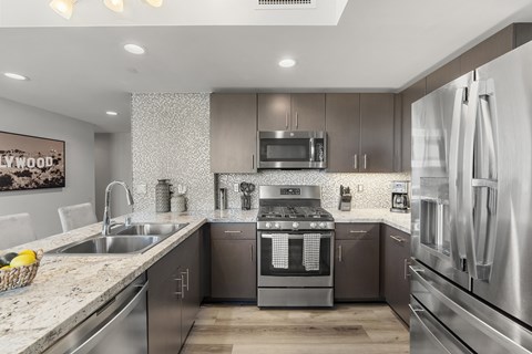 A modern kitchen with a stainless steel oven and microwave.