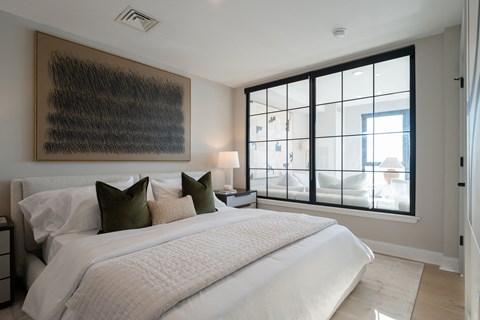 a bedroom with a large bed and a large window