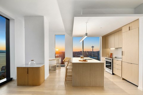 A modern kitchen with wooden cabinets and a large window overlooking the city.