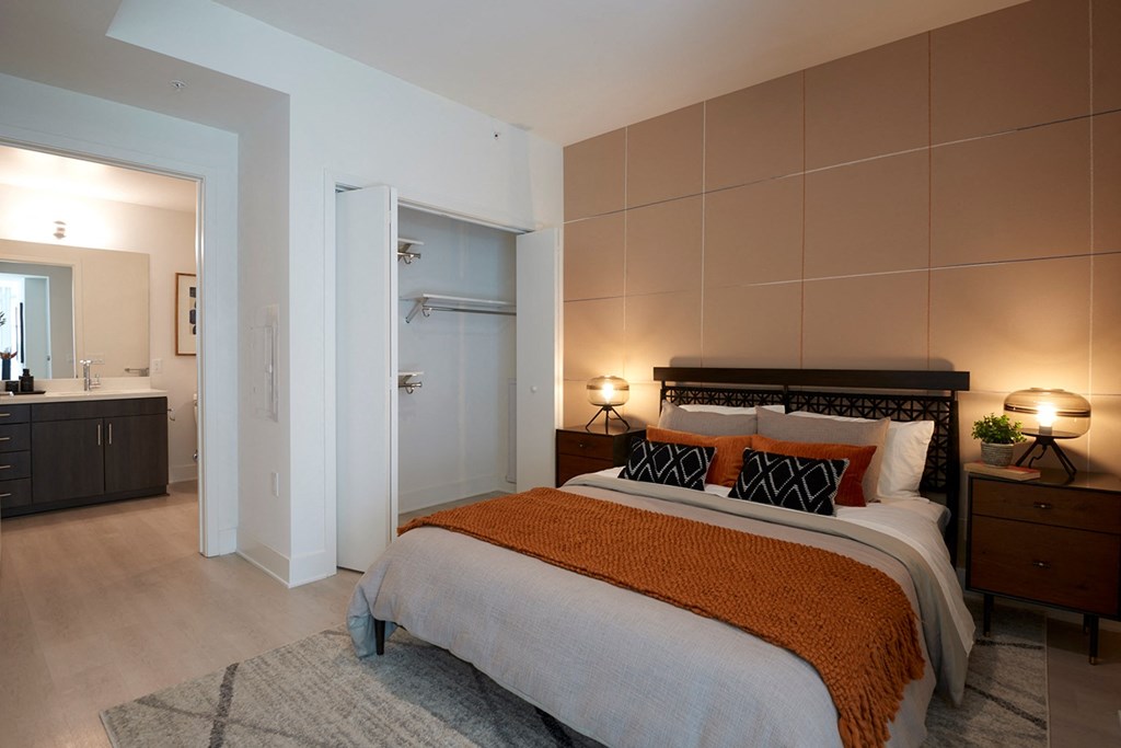 a bedroom with a bed and a bathroom with a sink