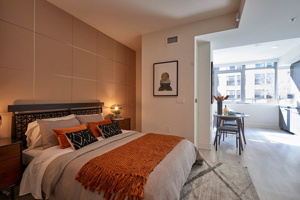 a bedroom with a bed and a table and a window