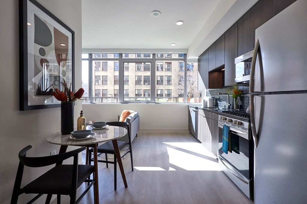 a kitchen and dining area with a large window and stainless steel appliances